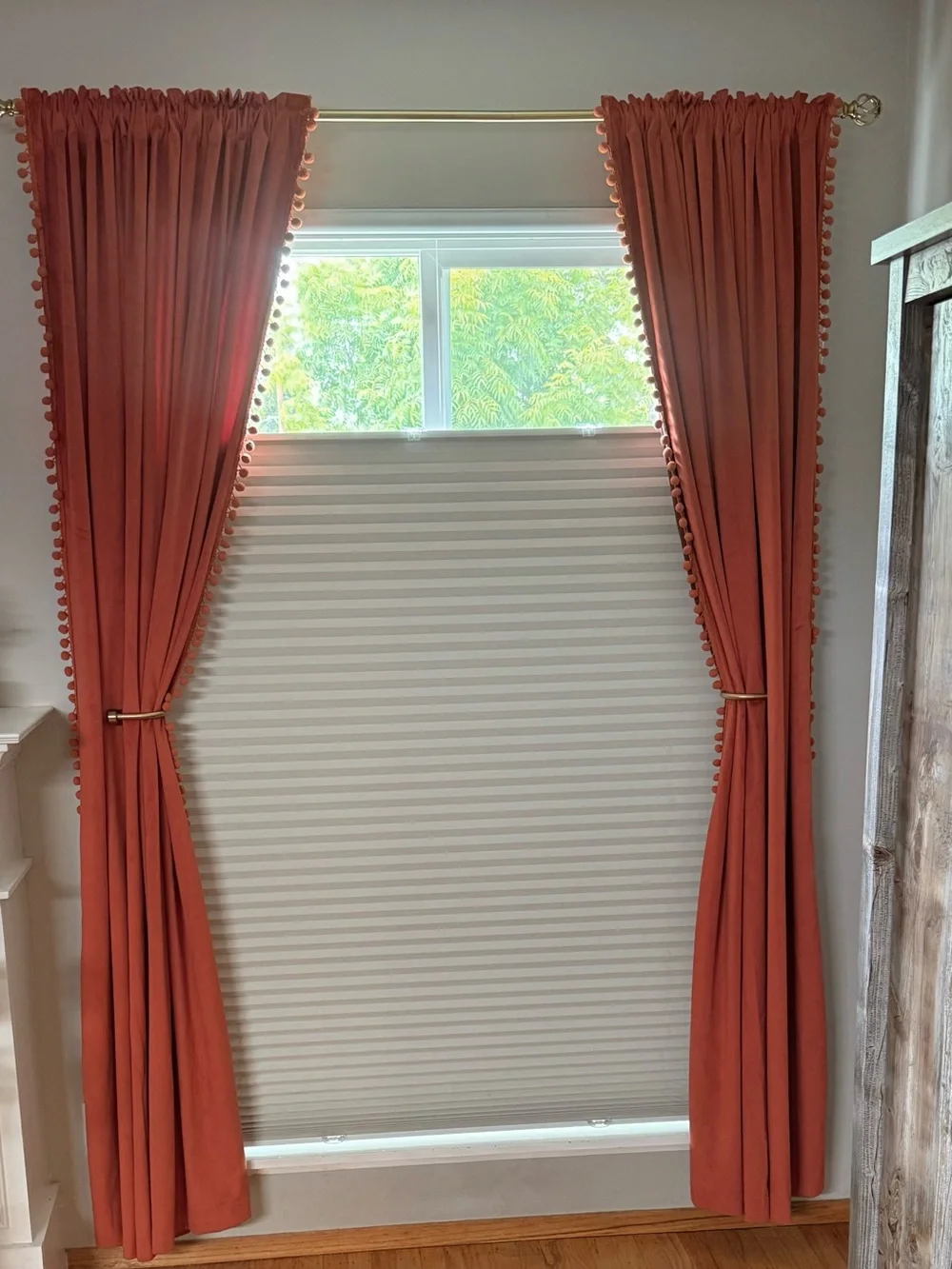 Burnt orange curtain panels with pompoms